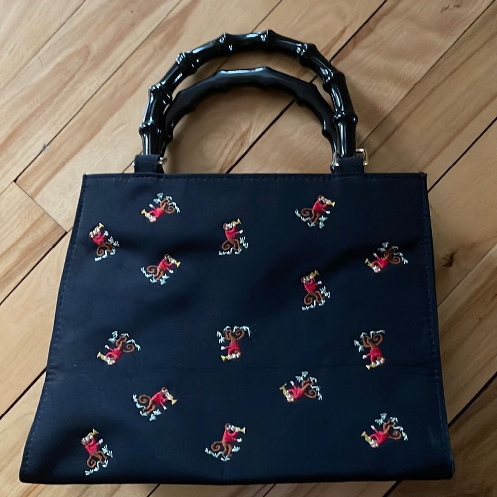 Black embroidered monkey faux bamboo handle bag. Approximately 9 x 8 x 3 1/2 in.
